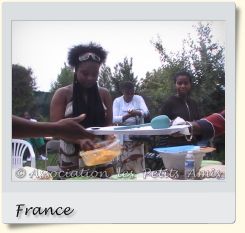 Le 16 août 2008 en après-midi, une membre bénévole de l'APA et d'autres participants au barbecue de Villetaneuse (93), en France. [Photographie © Association les Petits Amis.]