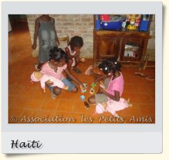 En août 2008, des bénéficiaires de l'APA et d'autres participants jouant à la poupée dans le salon du centre d’accueil « Les Oliviers », sur le Plateau de Salagnac, en Haïti. [Photographie © Association les Petits Amis.]