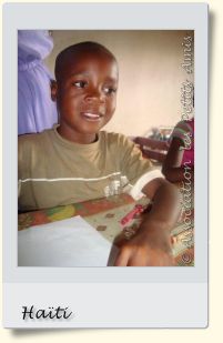 En août 2008, un bénéficiaire de l'APA à un atelier de dessin dans le salon du centre d’accueil « Les Oliviers », sur le Plateau de Salagnac, en Haïti. [Photographie © Association les Petits Amis.]